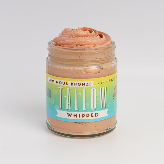 Lady May Tallow Luminous Bronze Whipped Tallow Moisturizer in 9 oz jar, showing smooth, bronze-tinted body cream with glossy texture.