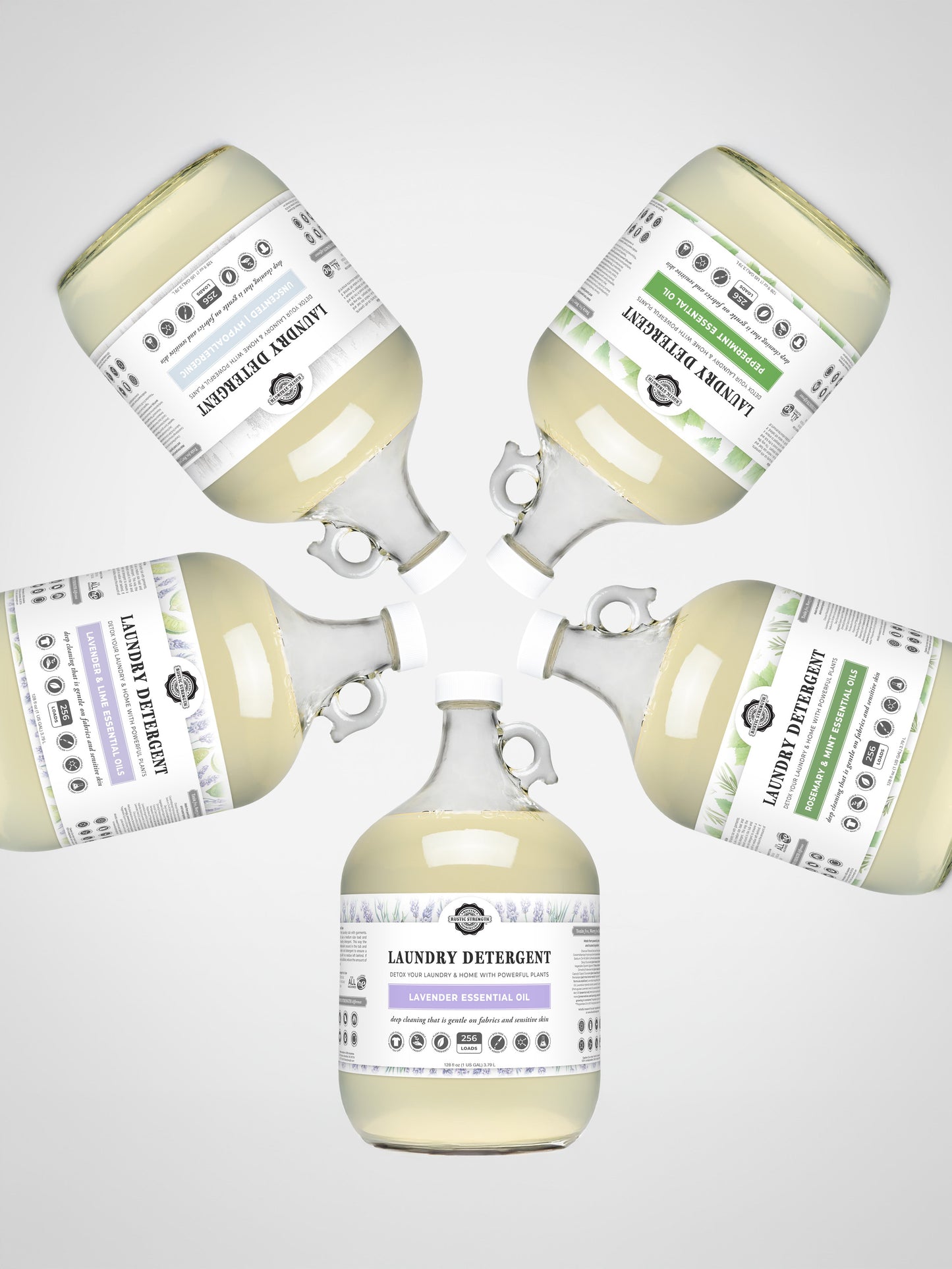 Five clear gallon jugs of Rustic Strength Laundry Detergent | Unscented are arranged in a circle on a light background. Each jug has a white label with black text; one features a green stripe, while the rest have purple accents.