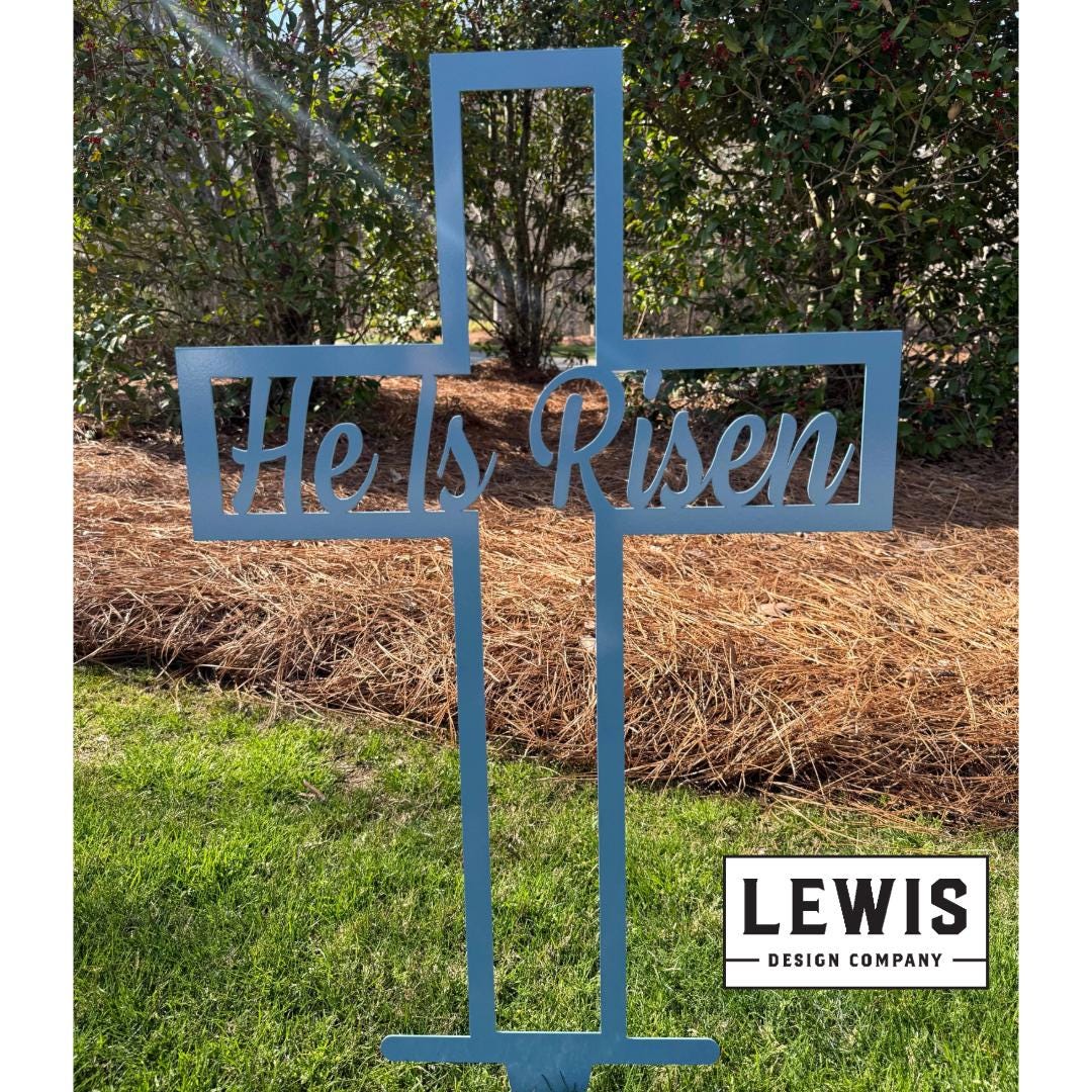 Pastel blue He Is Risen cross metal yard sign by Lewis Design Company, outdoor garden art for Easter, 8x4 inches.