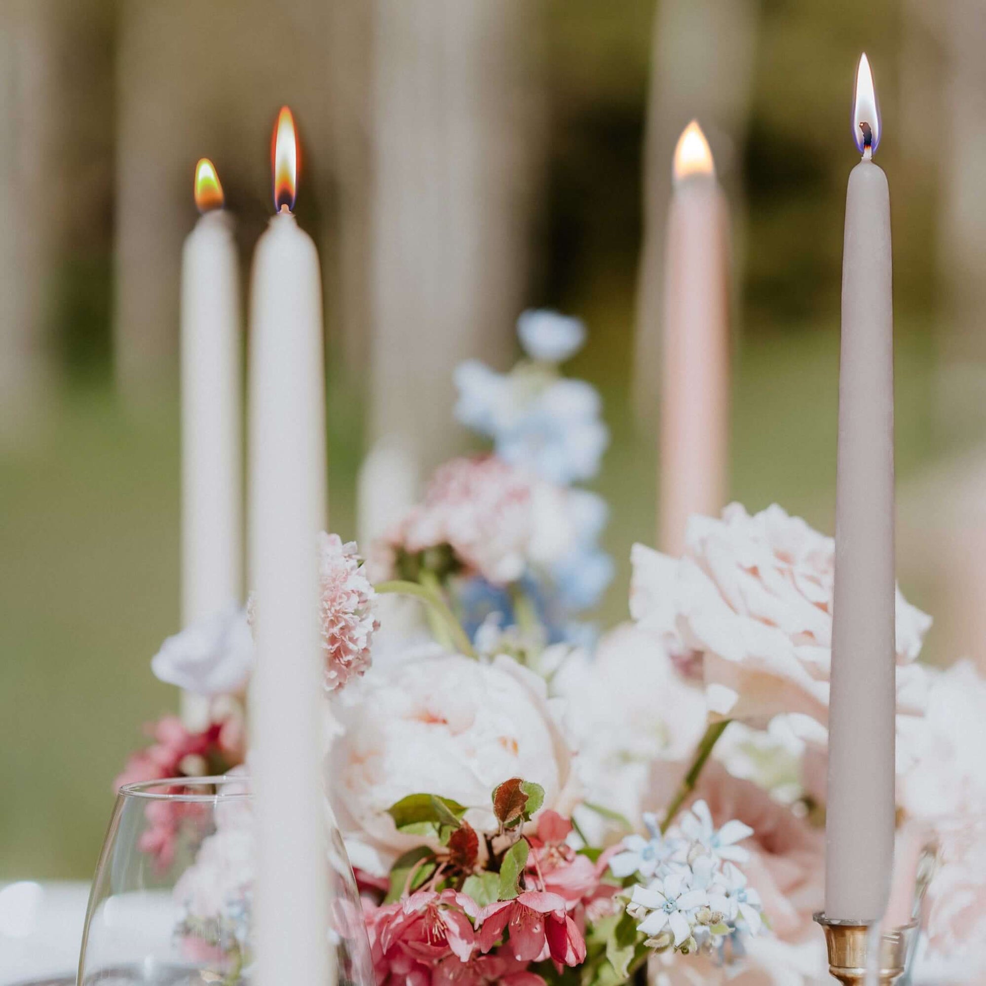 Bluecorn Candles hand-dipped beeswax taper candles in light grey and ivory, displayed on a wedding table for elegant decor.