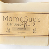 A 5 oz (141 g) MamaSuds Unscented No. 12 Bar Soap, wrapped in a tan label with small leaf illustrations—crafted from certified organic ingredients.