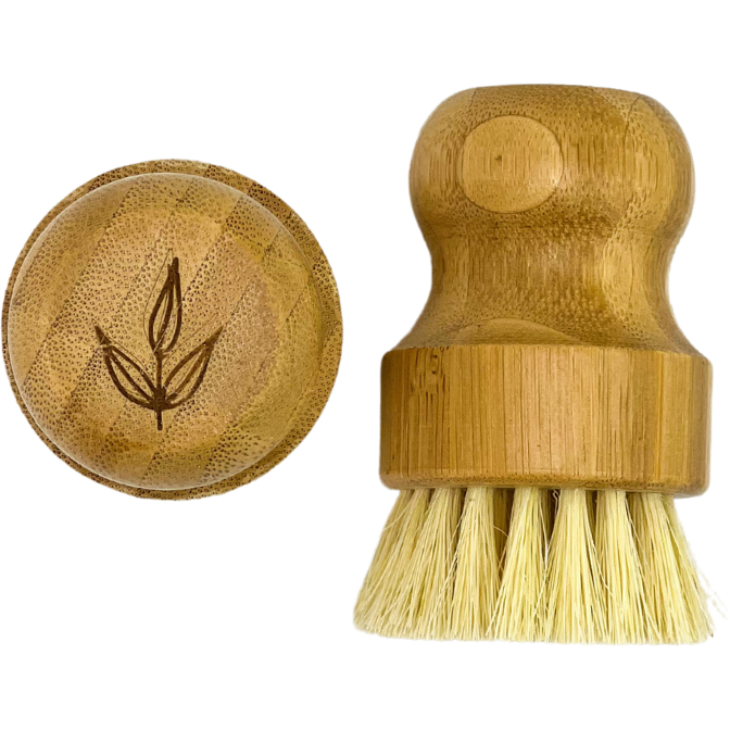 Two MamaSuds Bamboo Pot Brushes: one features a leaf-etched bamboo top, while the other stands upright to show its natural sisal bristles and ergonomic handle.