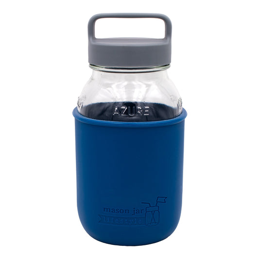 Deep blue Mason Jar Lifestyle 32oz glass water bottle with silicone sleeve, carry handle, and gray canister lid on a white background.