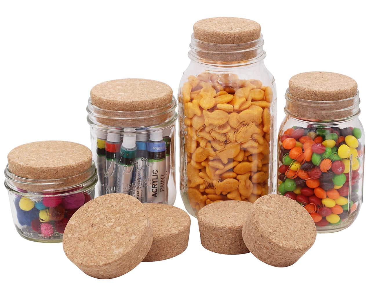 Four Mason Jar Lifestyle Cork Lids for Mason Jars are displayed in front of seven glass jars filled with items like acrylic paint tubes, goldfish crackers, pom-poms, and candies on a white background.