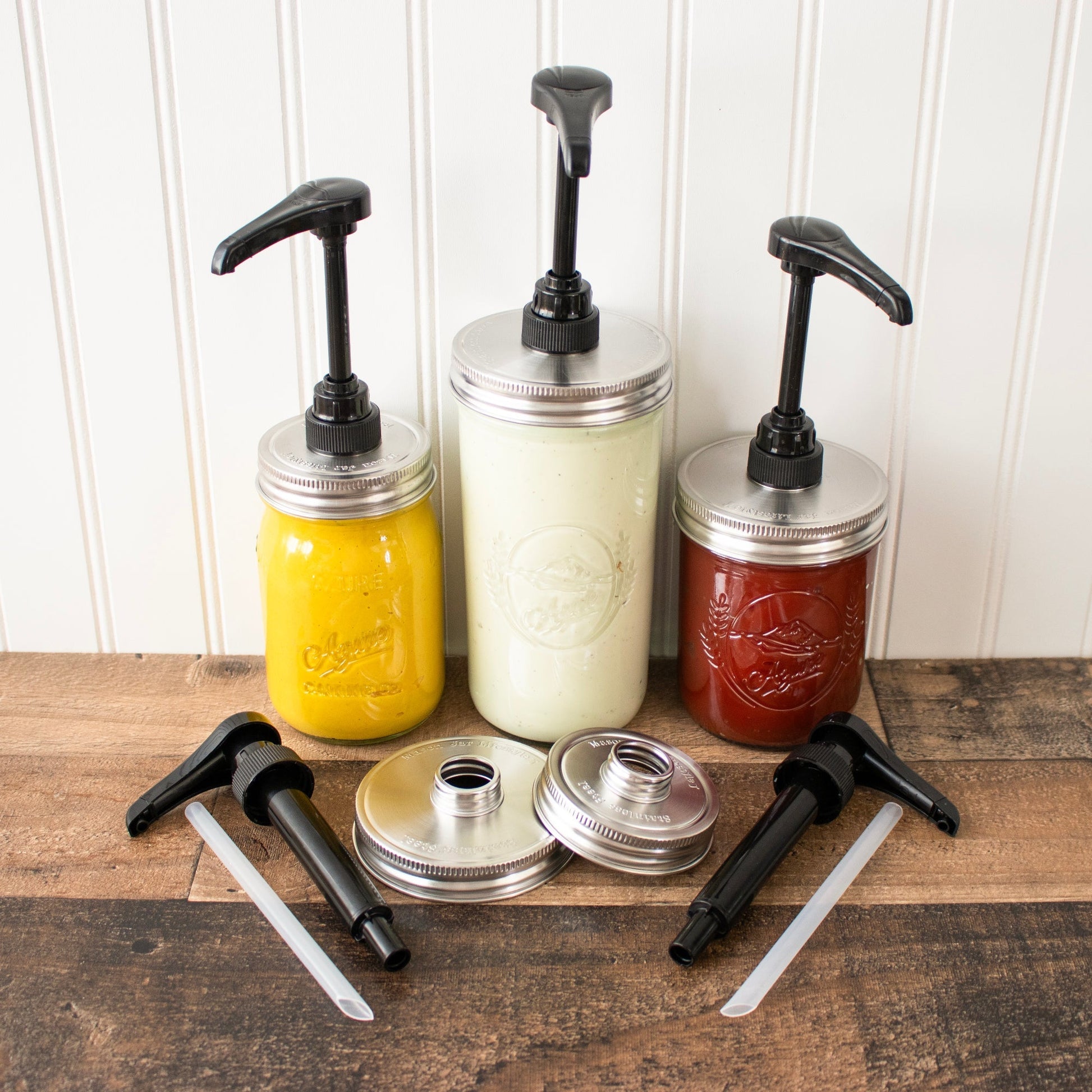 Food grade dispenser pump attached to a matte stainless steel lid on a regular-mouth Mason jar for liquids or condiments.