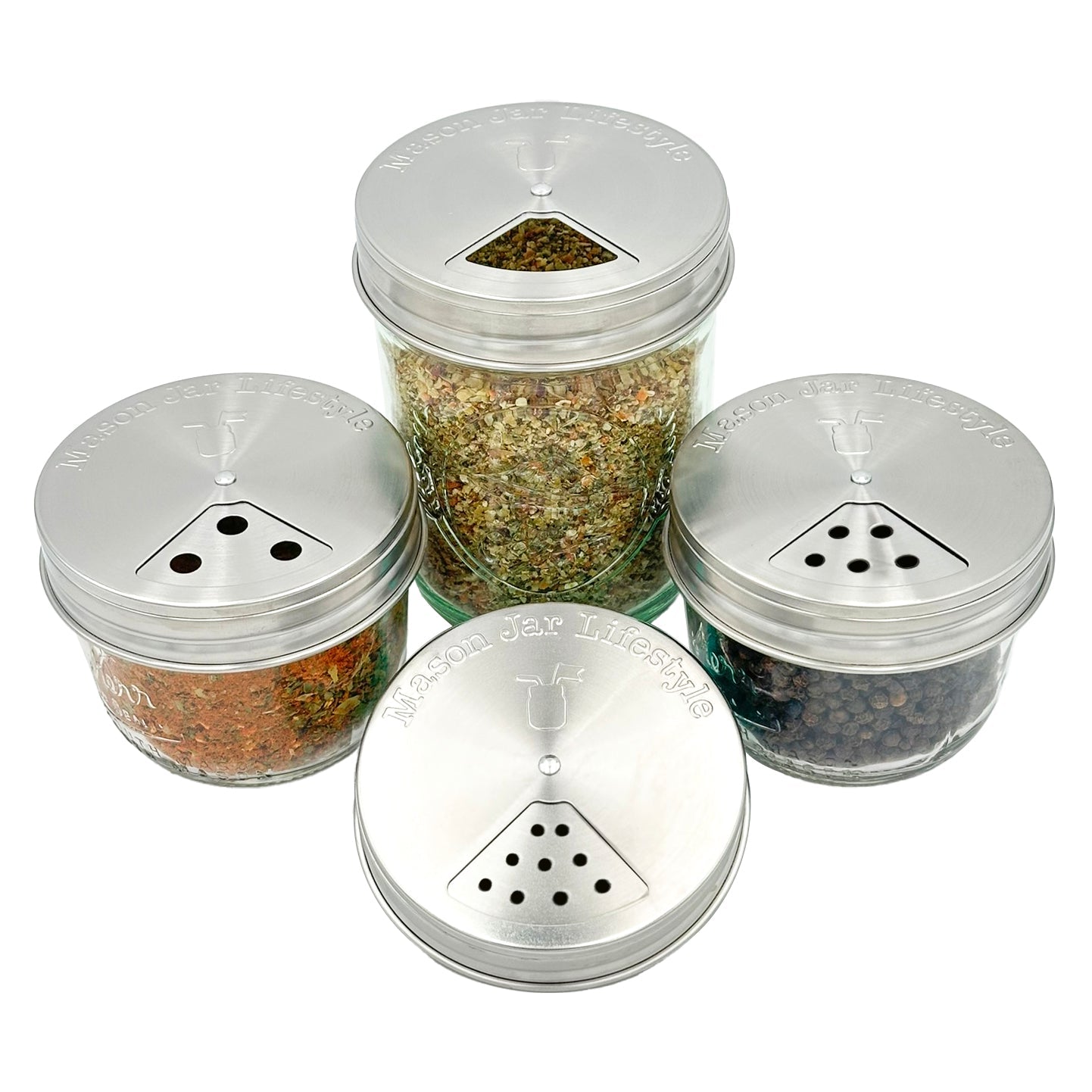 The Mason Jar Lifestyle Spice Shaker Stainless Steel Lids for Mason Jars 4 Pack includes four dishwasher-safe glass jars with adjustable stainless steel lids for shaking or pouring spices and herbs, each labeled "Mason Jar Lifestyle.