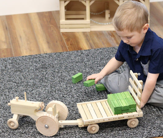 Amish-made wooden toy tractor and hay wagon set with hay bales, ideal for children's imaginative play.