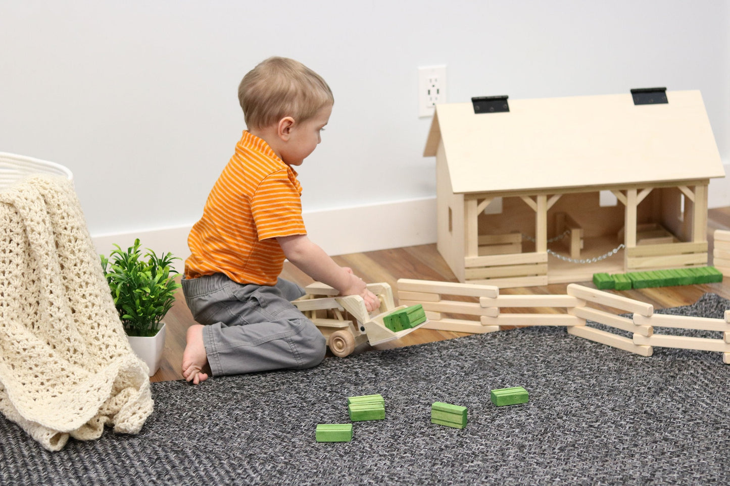 Wooden skid loader toy with a movable bucket, crafted by AmishToyBox.com, featuring detailed wooden construction and realistic design.