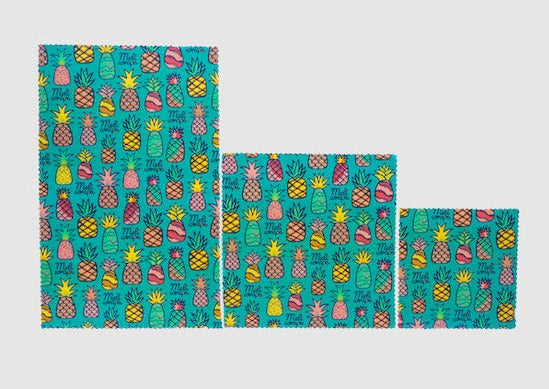 Three Meli Wraps beeswax food wraps in pineapple print, small, medium, and large sizes, with colorful fruit design.
