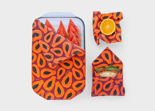 Set of three Meli Wraps beeswax food wraps in purple papaya print, small, medium, and large sizes for eco-friendly food storage.