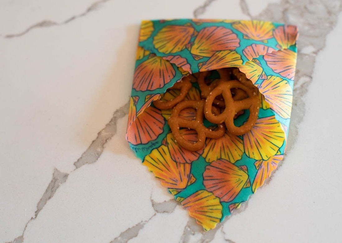 Set of Meli Wraps beeswax food wraps with sunrise shell print, shown in small, medium, and large sizes for food storage.