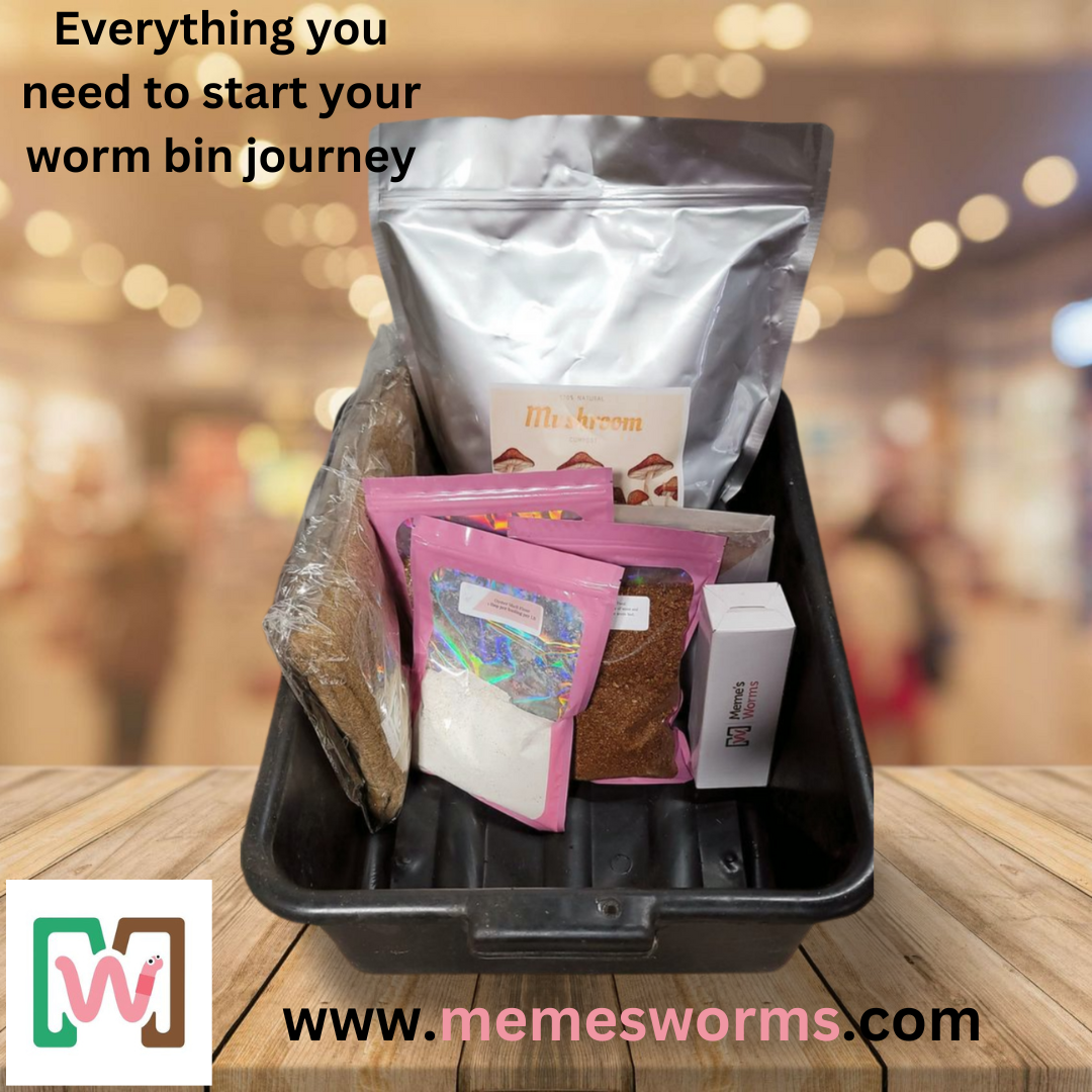 A black tray holds the Worm Bin Starter Kit from Memes Worms, with bags of soil, bedding, and worm chow on a wooden surface. Text reads: Everything you need to start your worm bin journey. Visit memesworms.com.