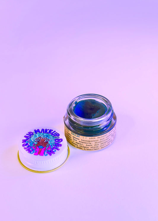 Plant Makeup Mermaid Makeup Balm in a decorative container with shimmering, mermaid-inspired packaging and colorful, creamy balm inside.