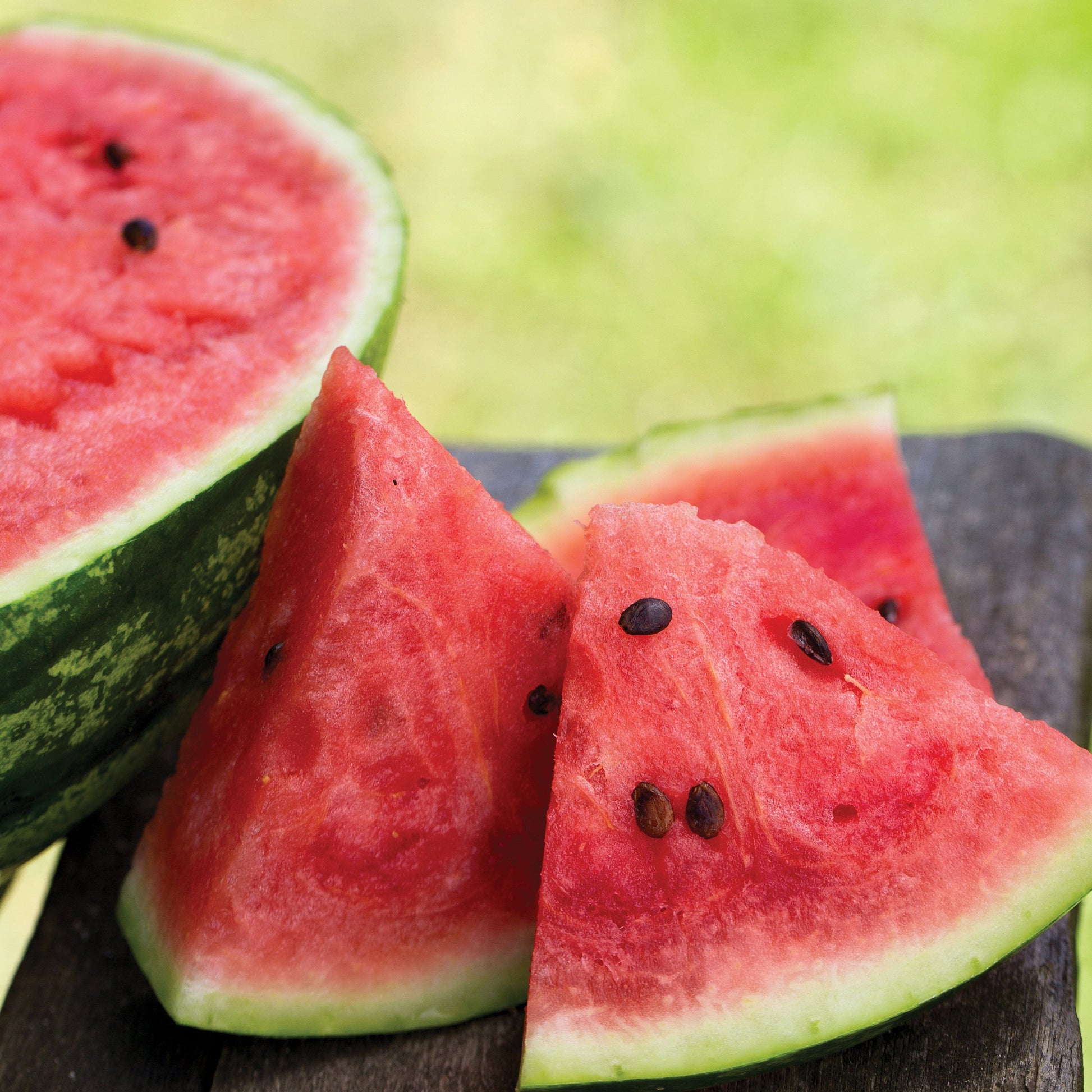 Fresh MIgardener Cal-Sweet Watermelon showing vibrant green rind and juicy red flesh with black seeds.