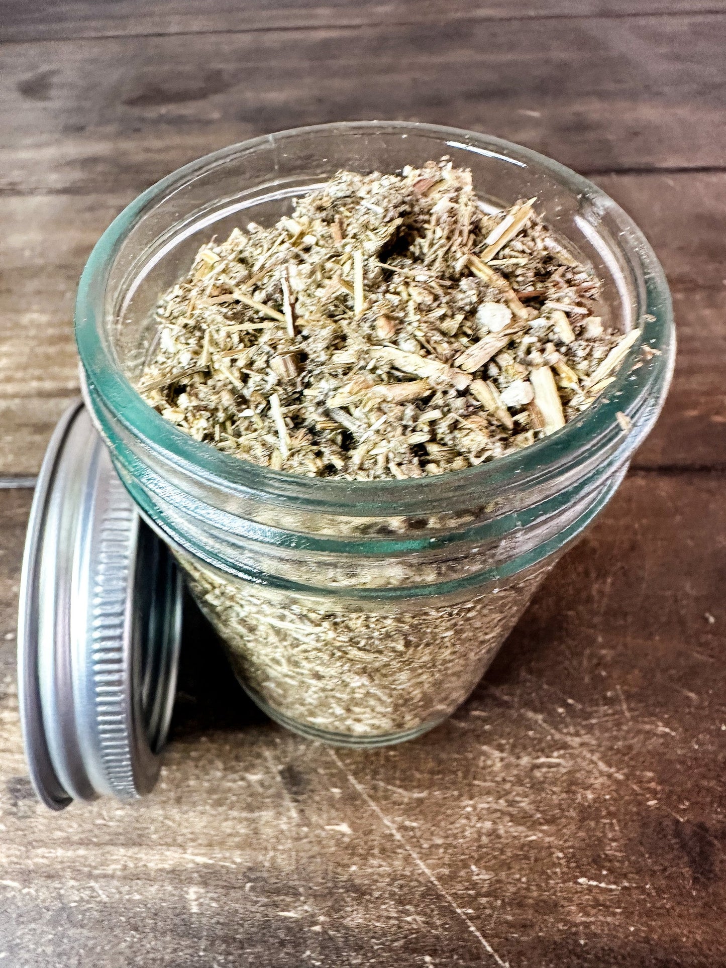 Small jar of dried mugwort herbs in a herbalroseapothecary herb jar for herbal remedies and natural herbal storage.