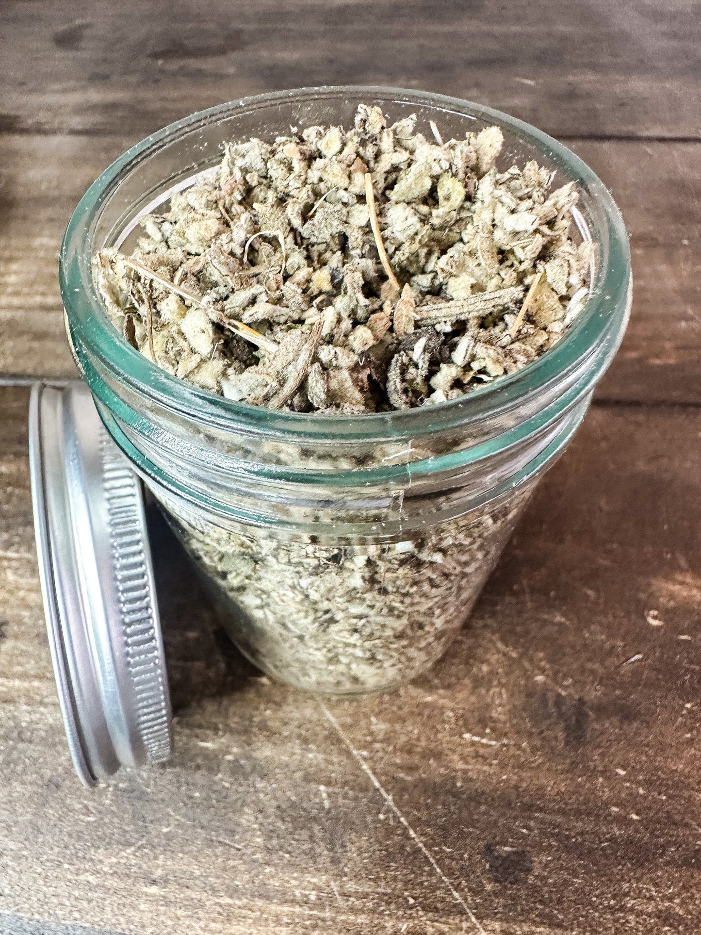 Small jar of dried mullein herbs in herbalroseapothecary herb jar, showcasing herbal remedy packaging and natural herb contents.