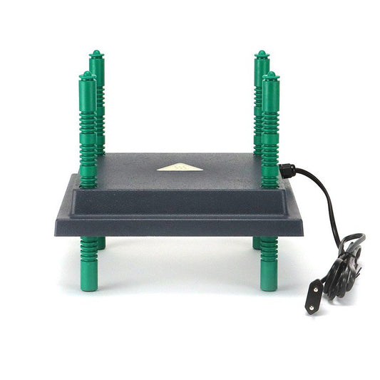 The image shows a My Pet Chicken Farmight Chick Brooder Heater Plate (black, rectangular) with adjustable height and four green legs pointing up, a power cord on the right, and a triangular label on top; the device is upside down.