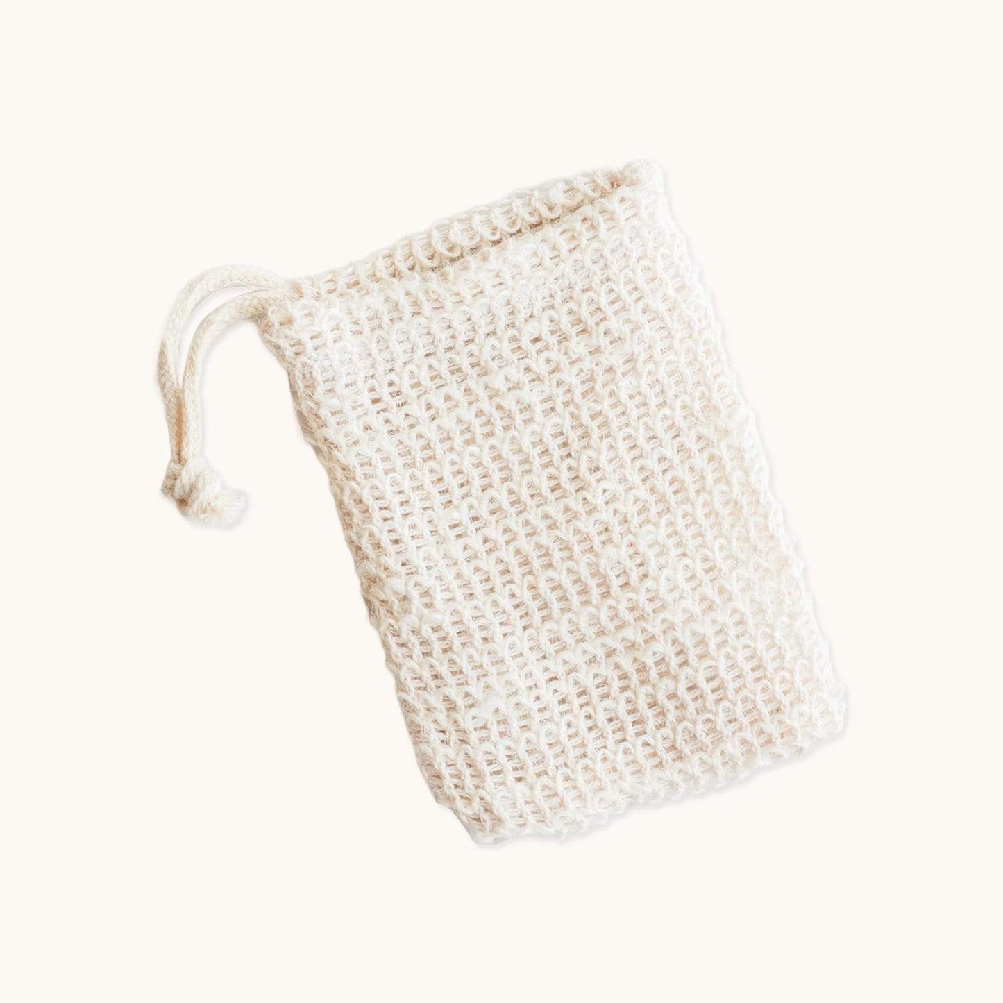 The Soap Saver Bag from ZeroWasteStore.com is a cream-colored, woven mesh pouch made of natural agave fiber with a drawstring—ideal as an exfoliating soap bag for a zero waste routine. Displayed on a plain light background.