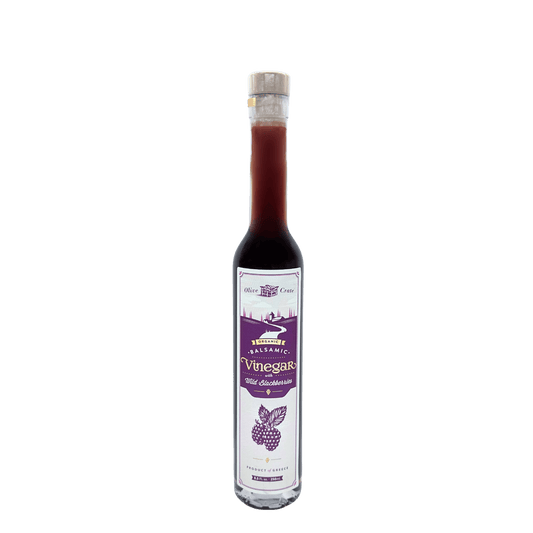 Organic balsamic vinegar with wild blackberry from Olive Crate, in a glass bottle showing dark vinegar and fresh blackberries.