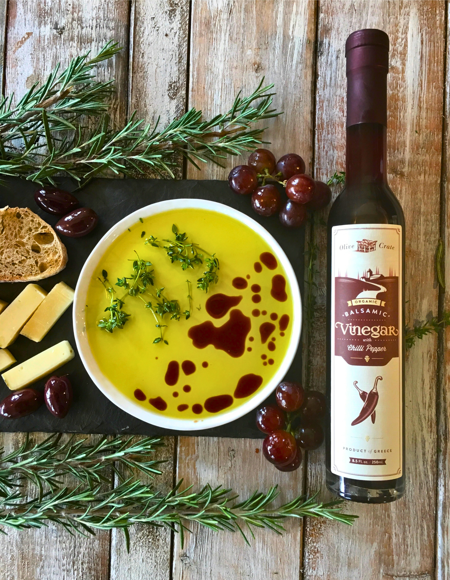 Organic balsamic vinegar with chili pepper from Olive Crate, shown in a glass bottle with red chili peppers and a dark, rich liquid.