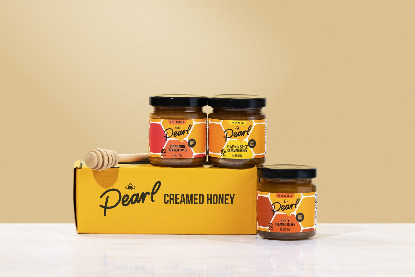 Assorted Pearl Honey Spreads Variety 3 Pack featuring different flavors in glass jars on a spice rack.