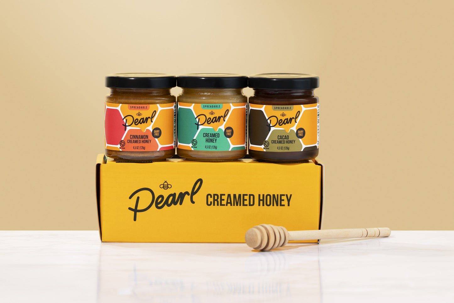 Three jars of Pearl Honey Spreads Variety 3 Pack with different flavored honey spreads on a spice rack.