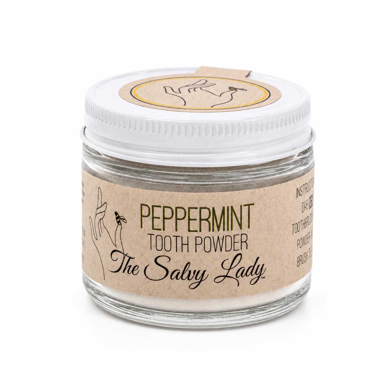 Peppermint tooth powder in a 2 oz container from The Salvy Lady, fluoride-free, shown in a natural setting with mint leaves.