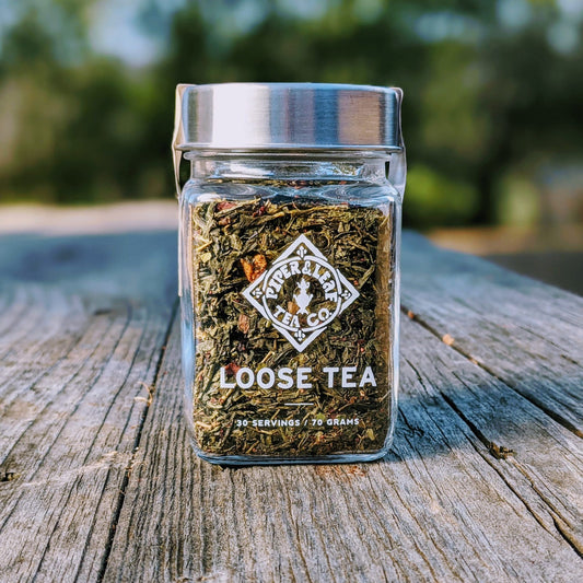 Glass jar of Piper and Leaf Tea Co. Sassyfras Strawberry loose leaf tea with vibrant red and green tea leaves visible inside.