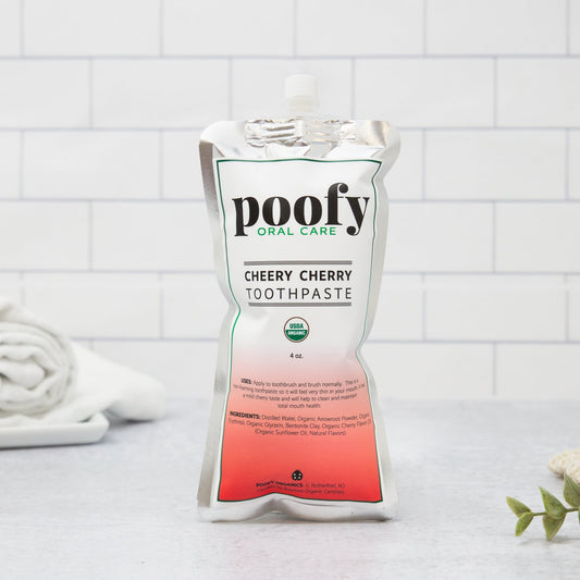Poofy Organics Cheery Cherry Toddler Toothpaste in a tube, featuring organic ingredients for gentle oral care for young children.