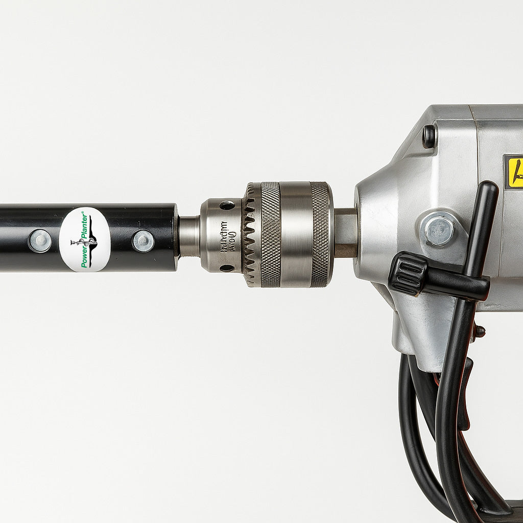 Close-up of a Power Planter Augers Heavy Duty 1/2" Hex Auger Adapter with black shaft, inserted into a drill's chuck. Drill wires and metallic casing are visible against a white background.