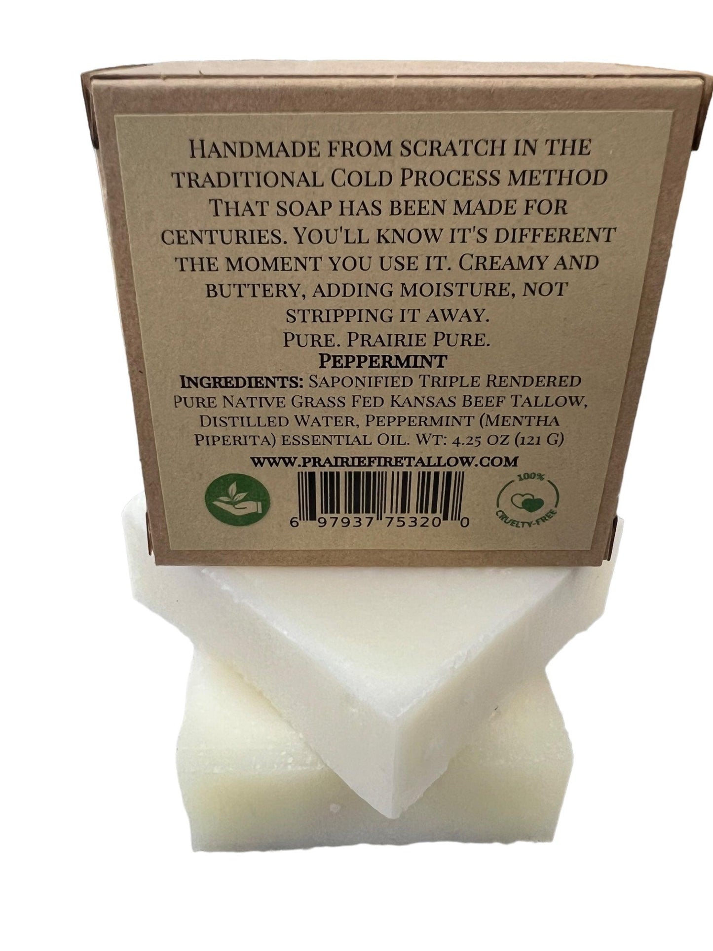 A Pure Beef Tallow Soap Bar by Prairie Fire Tallow, Candles, and Lavender stands upright in brown packaging detailing its handmade, cold process method. It’s natural, organic, grass-fed, for face/body/hair; pack includes barcode and website link.