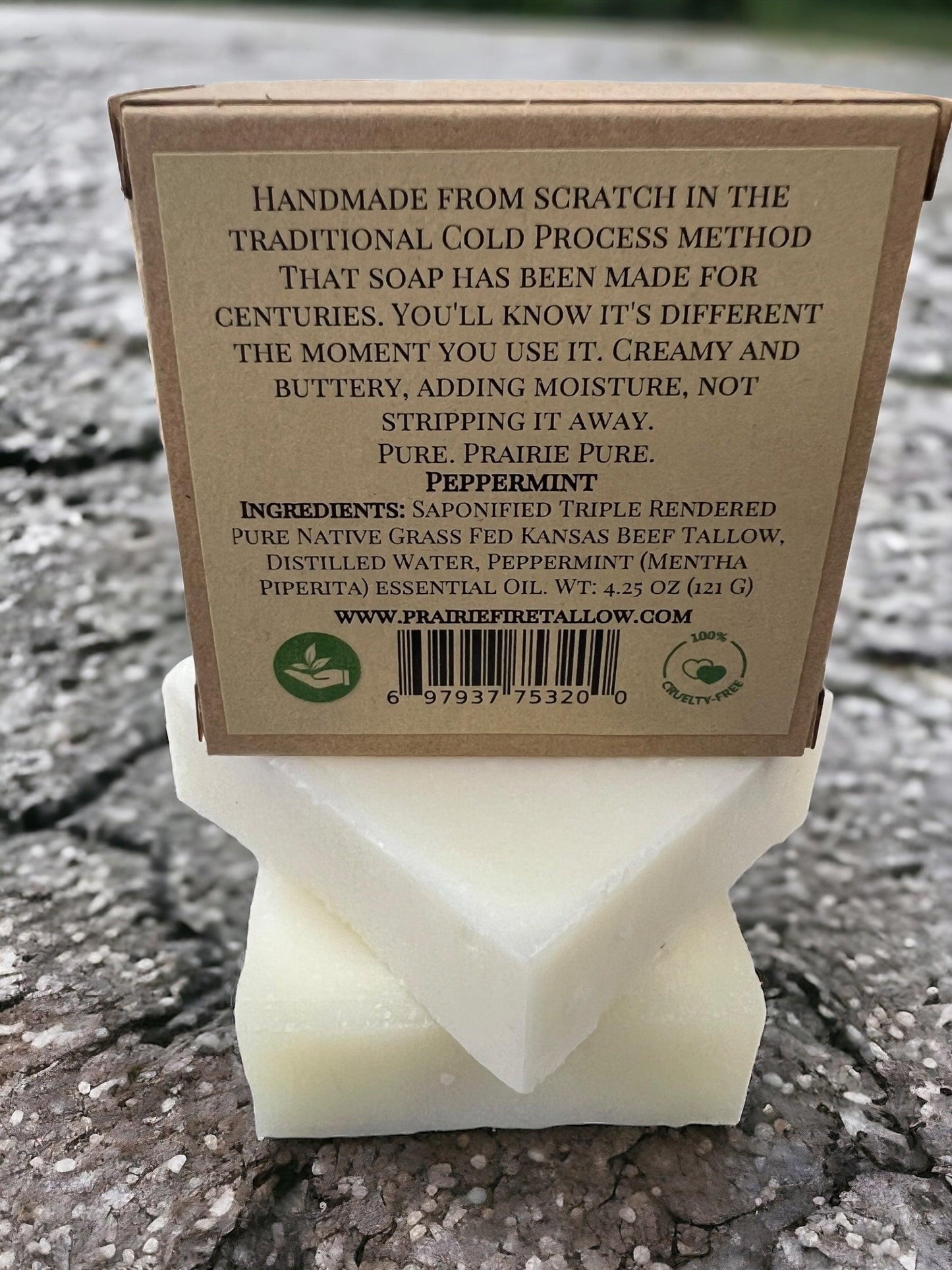 A Pure Beef Tallow Soap Bar 3-Pack by Prairie Fire Tallow, Candles, and Lavender—grass-fed, made in the USA—rests on stone; natural and organic for face, body & hair, it cleanses, moisturizes, soothes & hydrates.