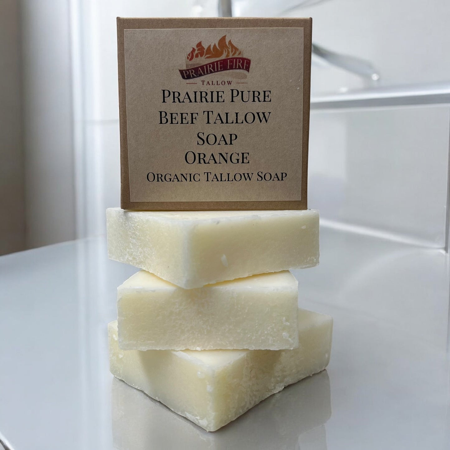 Three creamy, white bars of Pure Beef Tallow Soap by Prairie Fire Tallow, Candles, and Lavender are stacked on a clean surface. Made in the USA with grass-fed tallow, they cleanse, moisturize, soothe, and hydrate face, body, and hair.