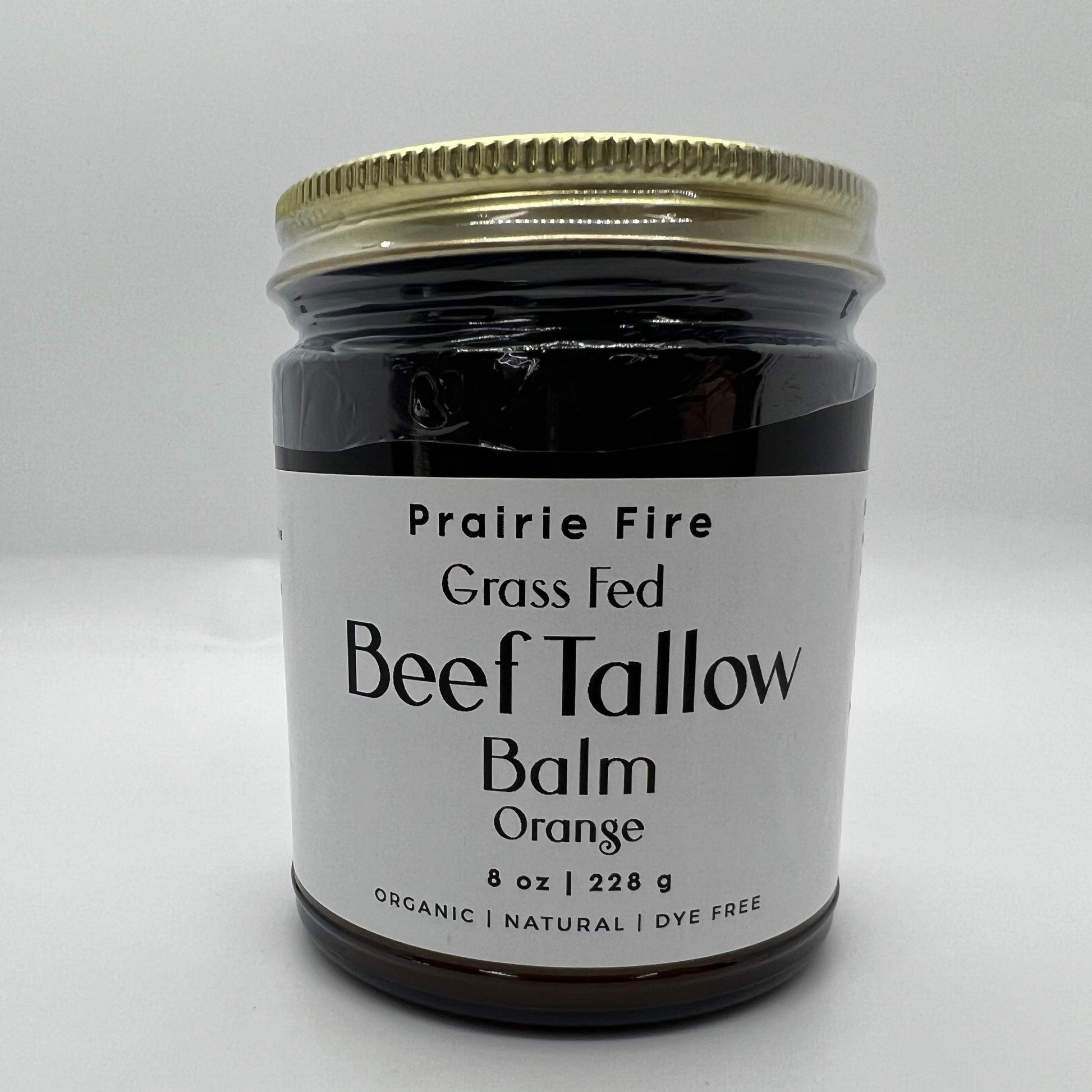 A glass jar with a gold lid labeled Prairie Fire Tallow, Candles, and Lavender Beef Tallow Balm - 8 oz, organic grass-fed and finished, made in the USA—an ideal natural moisturizer for skin care—sits on a white surface.