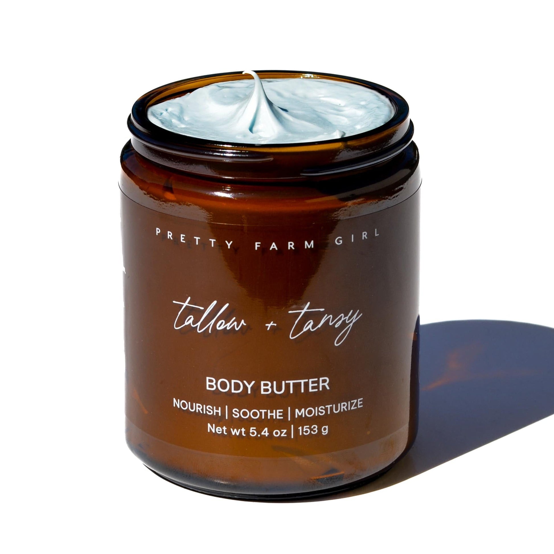 Cream jar of Pretty Farm Girl Tallow + Tansy Body Butter, showing the natural cream texture in a clean container.