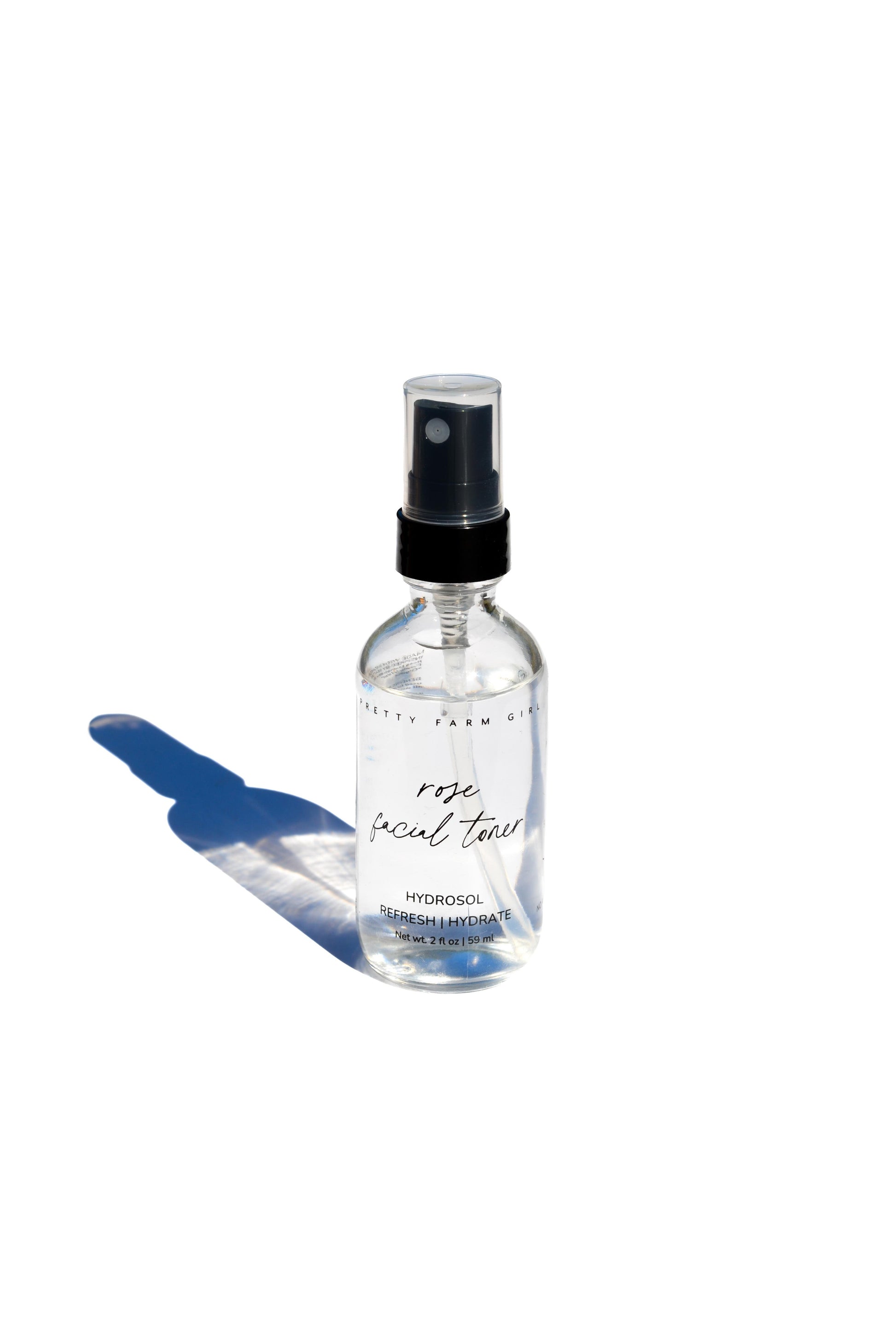 Pretty Farm Girl Organic Pure Rose Facial Toner in a 2 oz bottle, featuring a clear liquid and a white cap.