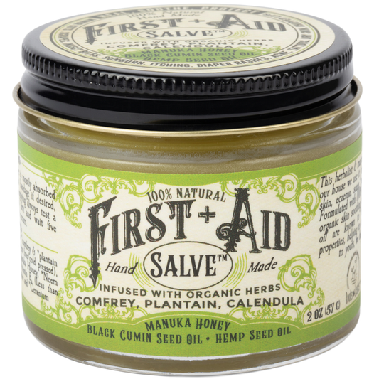 Bottle of Roots and Leaves LLC First Aid Salve for body care, with herbal ingredients and soothing application in a natural setting.
