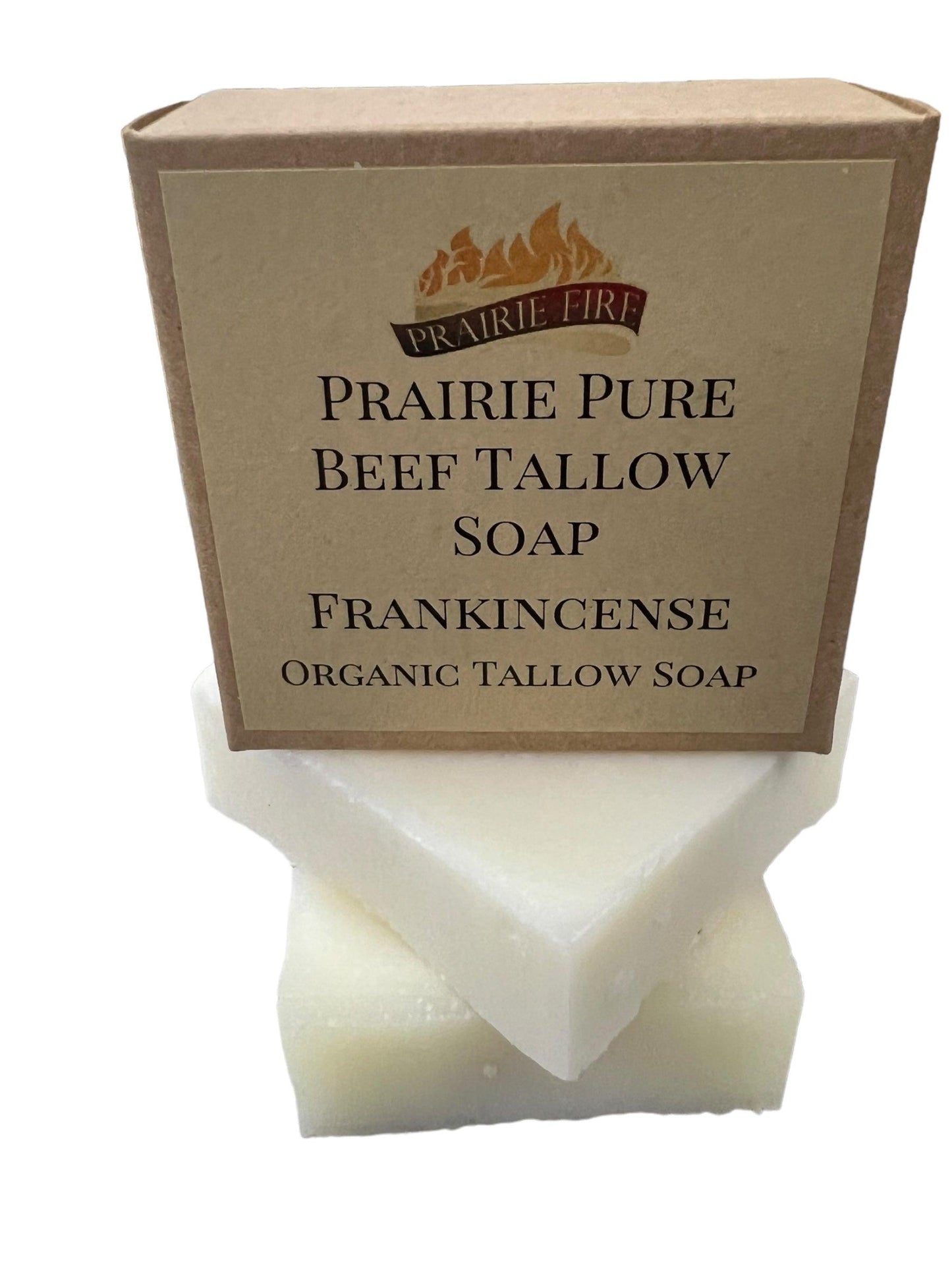 A box labeled Prairie Fire Tallow Pure Beef Tallow Soap Bar (3 Pack), made from grass fed, finished beef in the USA, rests on two white soap bars for face, body, and hair against a clean white background.