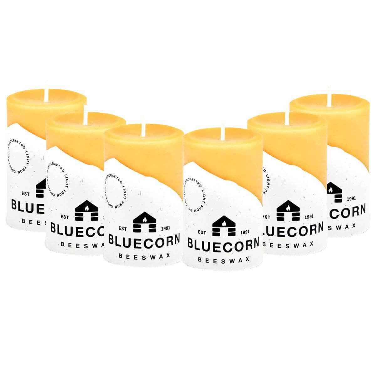 Set of blue beeswax pillar candles by Bluecorn Candles, showcasing tall, natural beeswax candles with a warm glow.