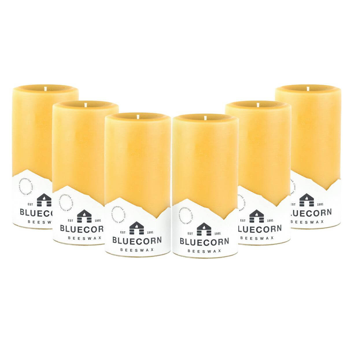 Pure beeswax pillar candles by Bluecorn Candles, showing tall, natural yellow candles with smooth surfaces and wicks.