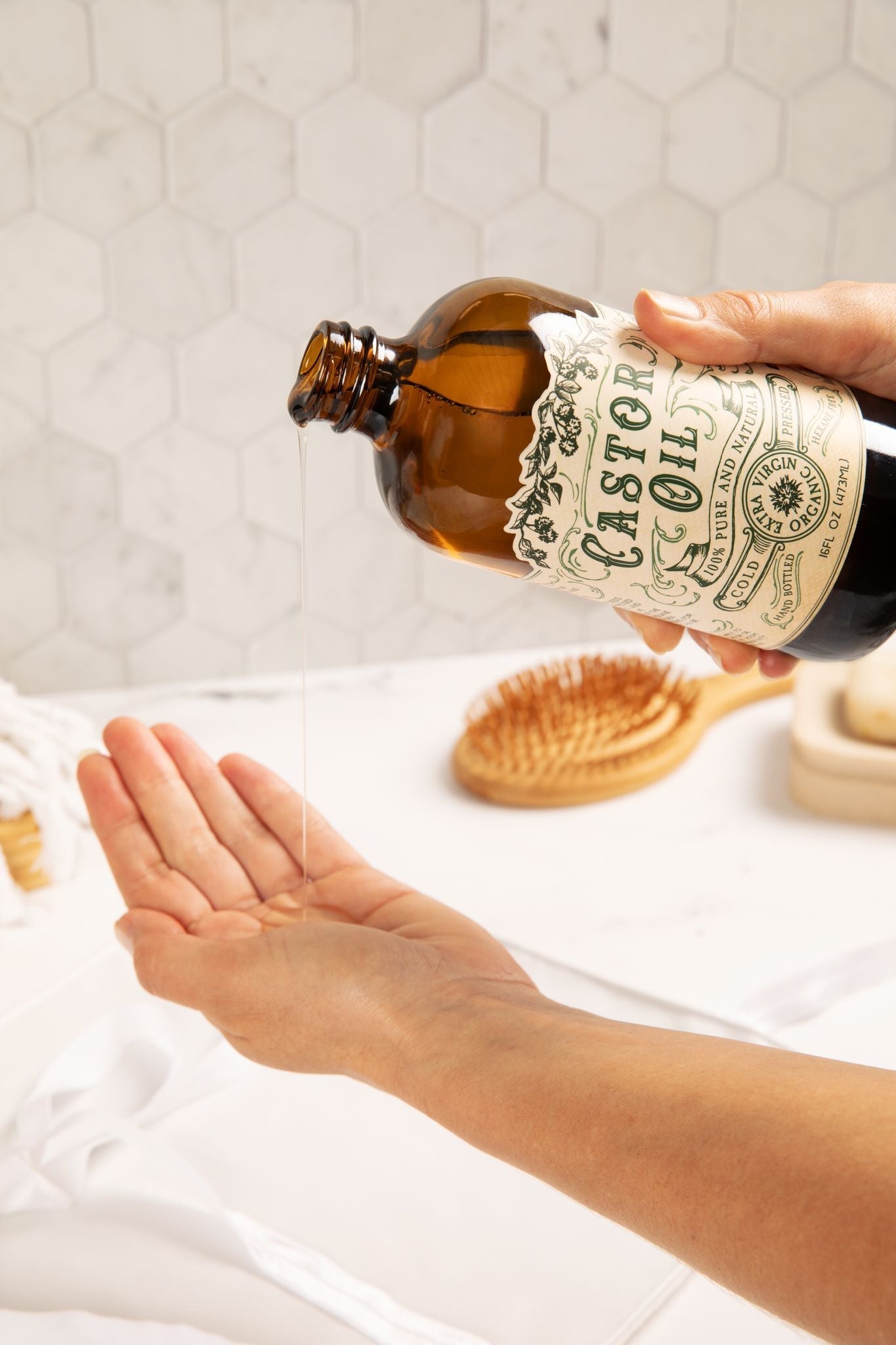 Organic cold pressed castor oil by Roots and Leaves LLC in a 16 oz bottle, showing clear, golden liquid in a glass container.