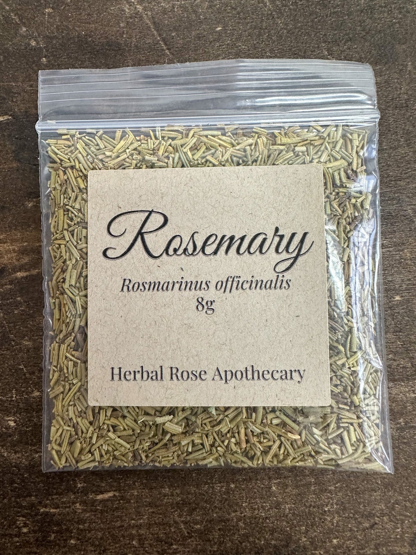 Dried rosemary herb from HerbalRoseApothecary in an 8g package, showing fresh green needle-like leaves on a neutral background.
