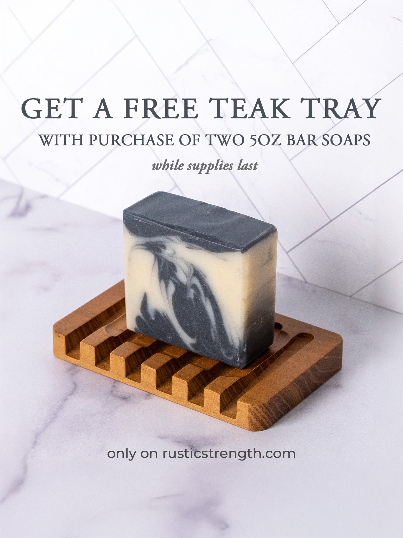 A black and white marbled Bar Soap | Detoxifying Charcoal by Rustic Strength sits on a wooden tray. Text reads: Get a free teak tray with purchase of two 5oz bar soaps—while supplies last. rusticstrength.com below.