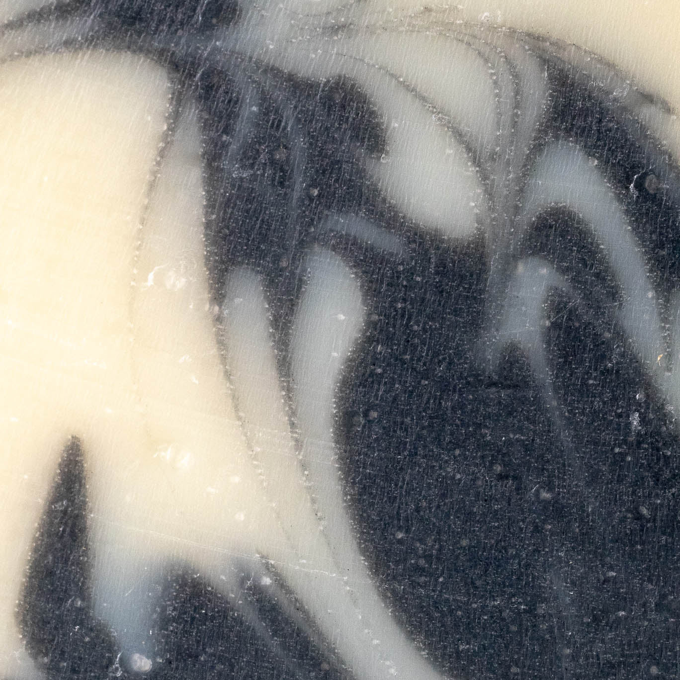 Close-up of Rustic Strengths Bar Soap | Detoxifying Charcoal, showcasing marbled black and white swirls with fine lines and subtle raised areas, resembling a polished cold-process soap for sensitive skin.