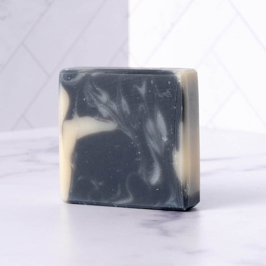 Rustic Strength detoxifying charcoal bar soap in a 2.5 oz bar, featuring a black, textured surface ideal for deep cleansing and skin refreshment.
