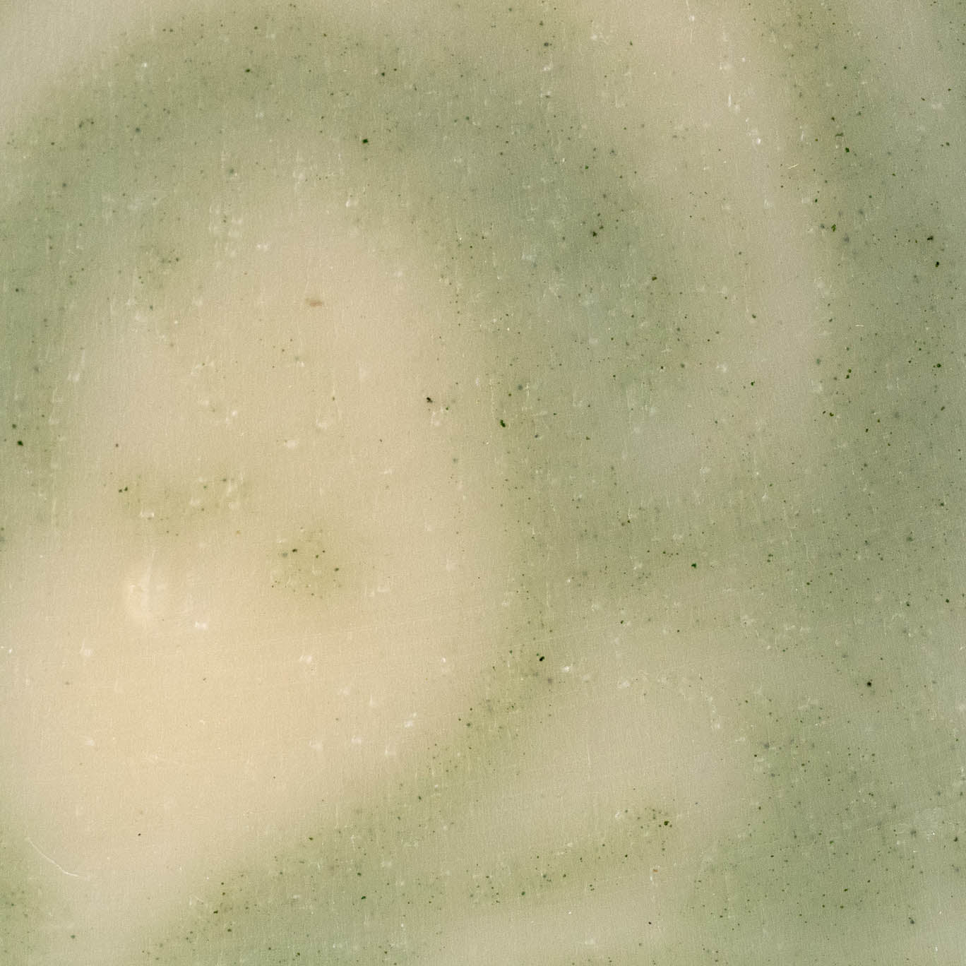 A close-up of Rustic Strength’s Bar Soap | Peppermint Tea Tree shows its light beige cold process surface, subtle greenish tones, and small specks for a marbled, textured look.