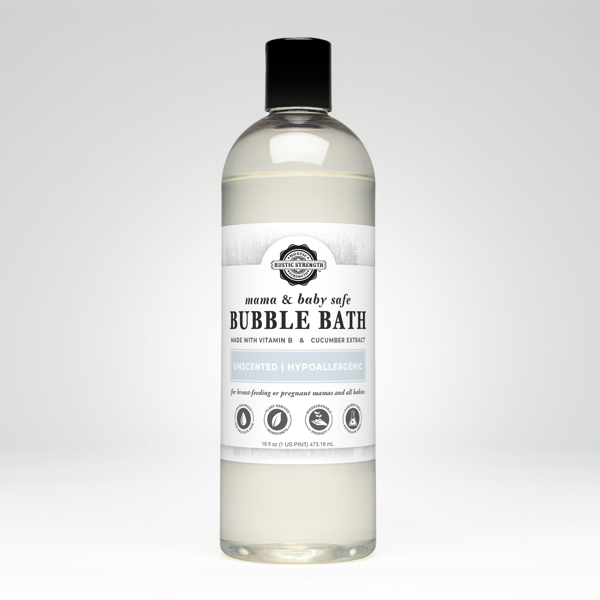 A clear bottle of Rustic Strength Bubble Bath | Mama + Baby Safe with a white label, black cap, and light yellow liquid. The label notes it’s hypoallergenic, unscented, and enriched with Vitamin B Complex and cucumber extract.