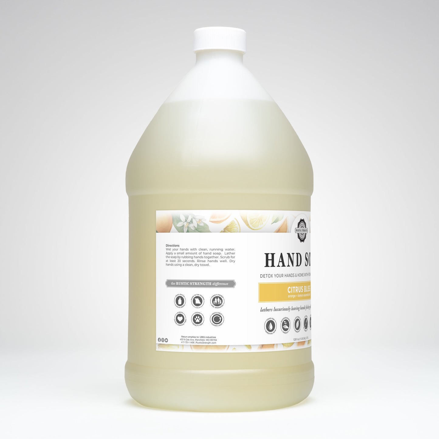A large, transparent plastic jug with a white cap contains Rustic Strength Hand Soap | Citrus Bliss. The label displays the product name, instructions, and icons. The background is plain white.