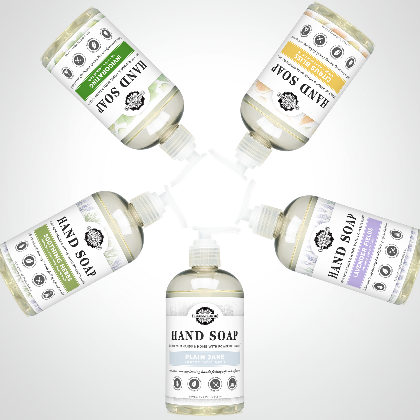Five bottles of Rustic Strength Hand Soap | Mama + Baby Safe, each featuring a unique scent and color-themed label, are arranged in a circle with pumps outward against a soft gradient background.