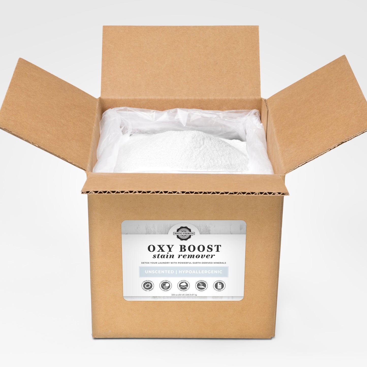An open brown cardboard box labeled Rustic Strength Oxy Boost Stain Remover reveals a large plastic bag of white powder. The label states it is unscented, hypoallergenic, and toxin free for safe cleaning.